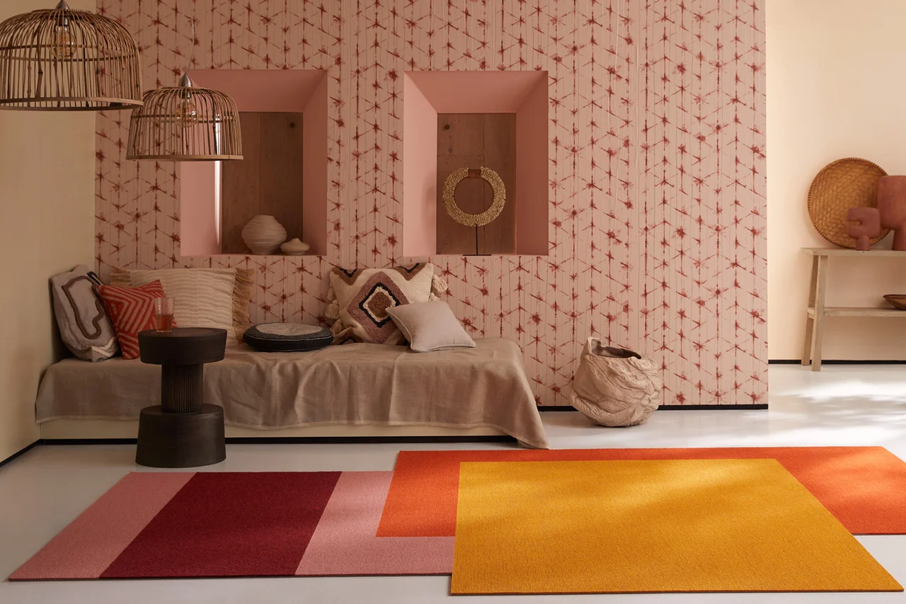 Illustration - Ihr Experte für schönes Wohnen - Ein Ziegenhaar Naturteppich in rot orange Tönen liegt im Zimmer
